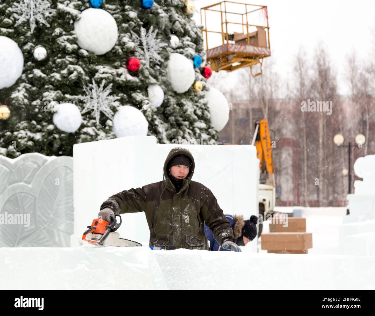 Worker with a chainsaw in hand at the assembly site Stock Photo