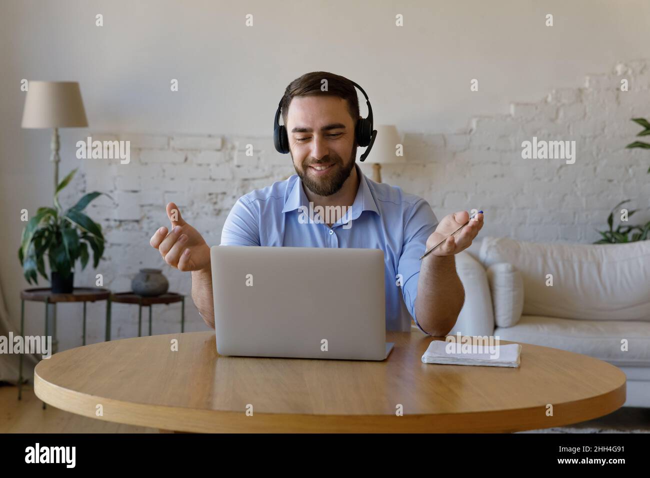 Happy adult male student studying on Internet from home Stock Photo