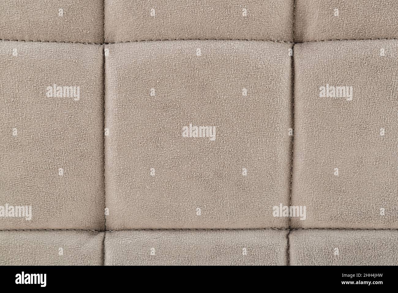 Texture beige fabric. Background of a soft pouf. Stock Photo