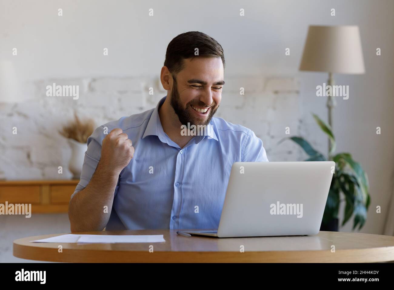 Excited happy guy getting good news, looking at laptop display Stock Photo