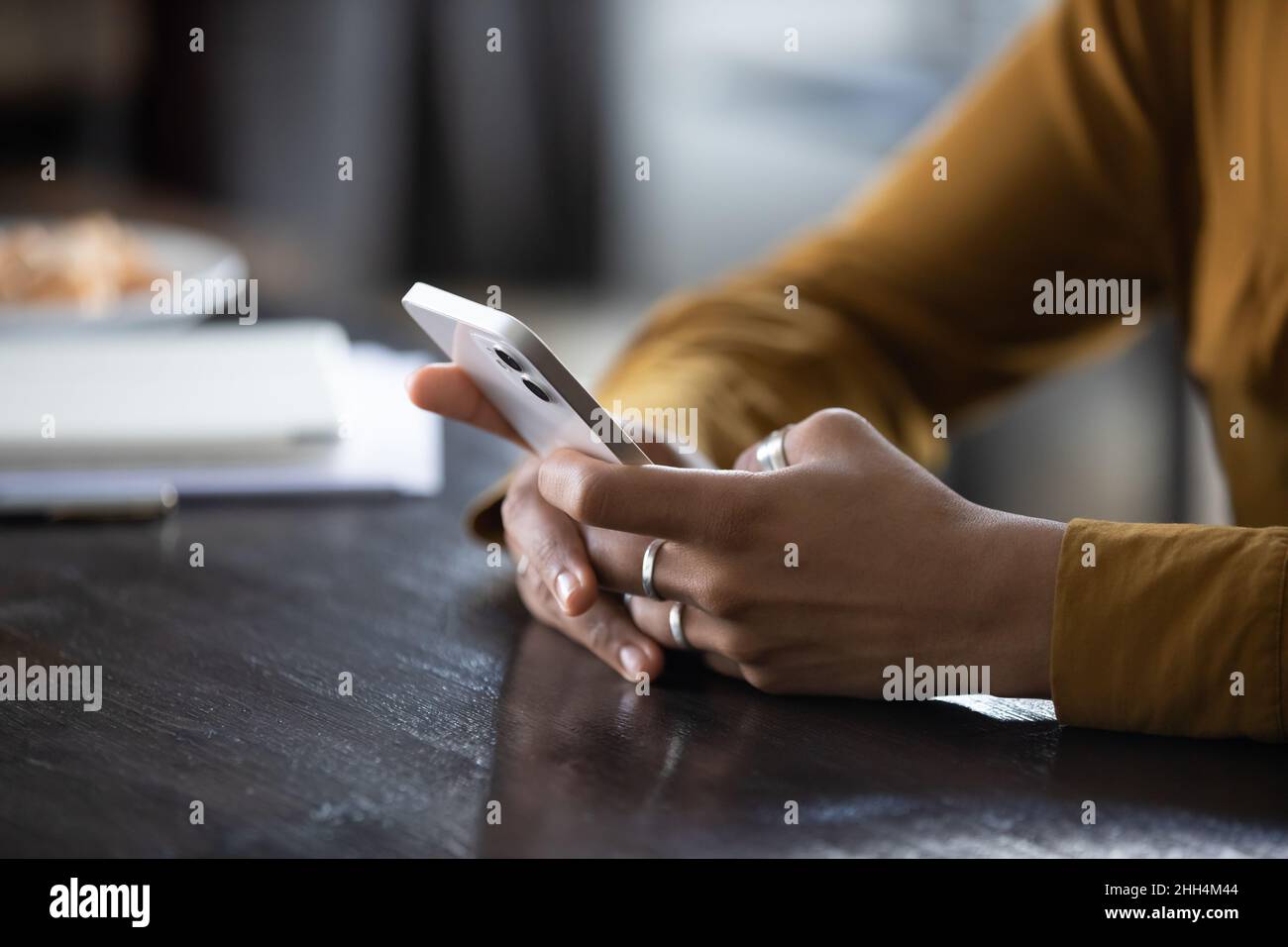 Hands of young dark skinned woman using app on phone Stock Photo
