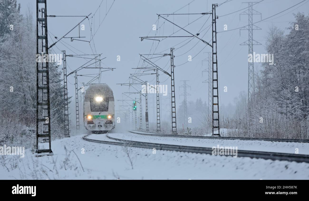 Passenger train on track in heavy snowfall Stock Photo