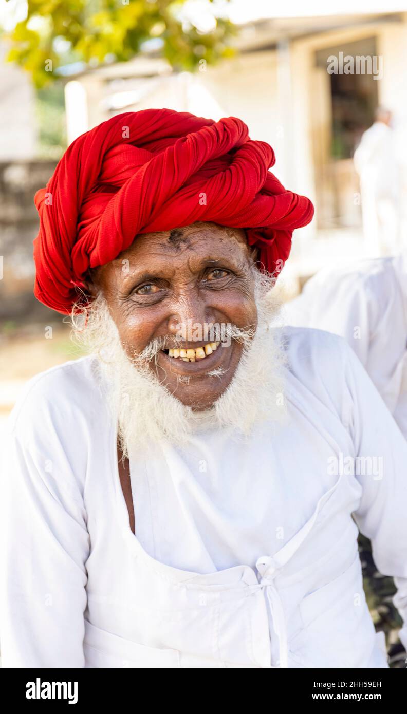 Jawai, Rajasthan, India - September 2021: Portrait of a male shepherd of the Rabari ethnic group in a national headdress and traditional white dress, Stock Photo