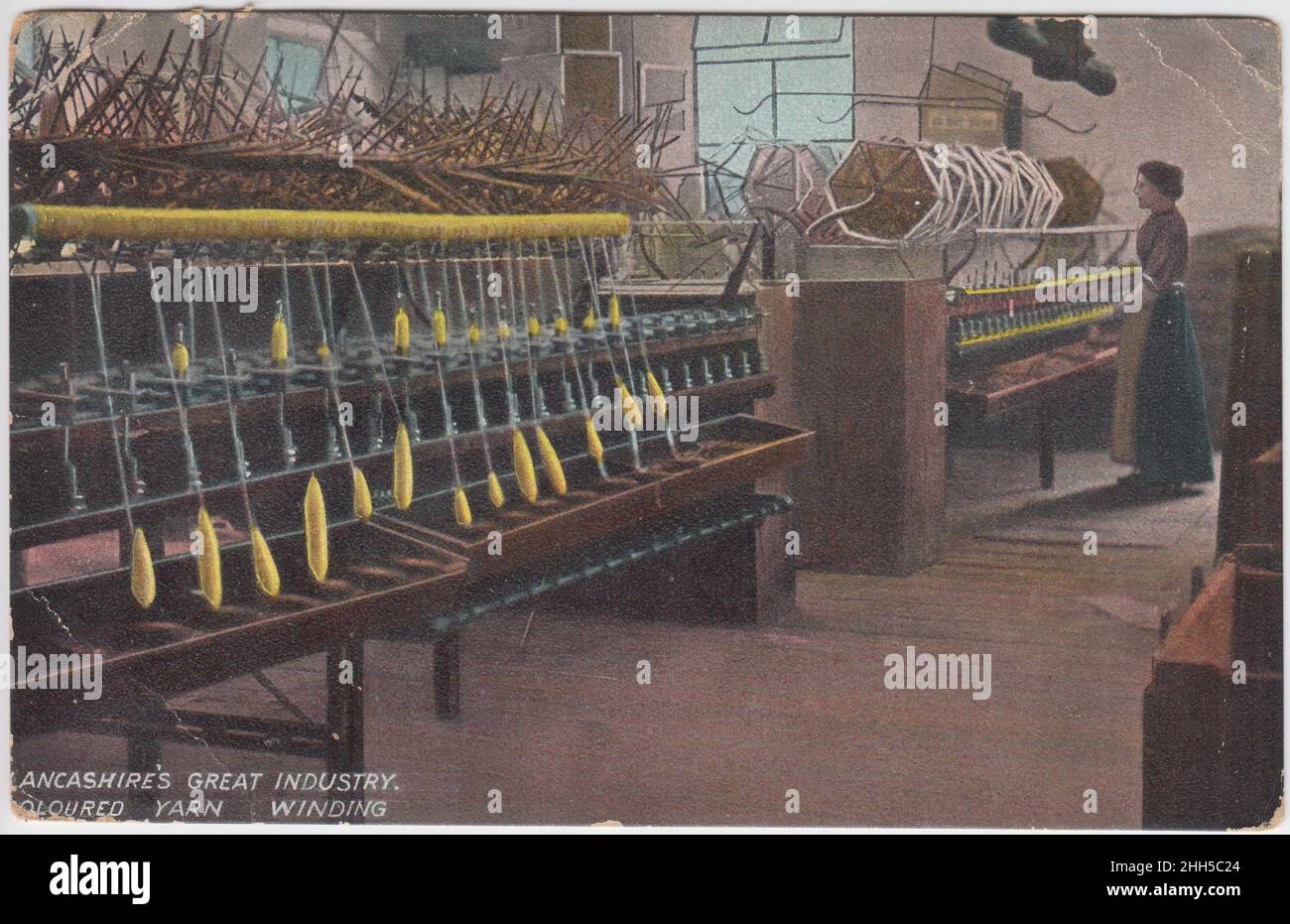 'Lancashire's great industry, coloured yarn winding': woman standing by mill machinery. The colourised postcard was published by L. Pickles & Co. of Bradford, and was posted in 1920 Stock Photo