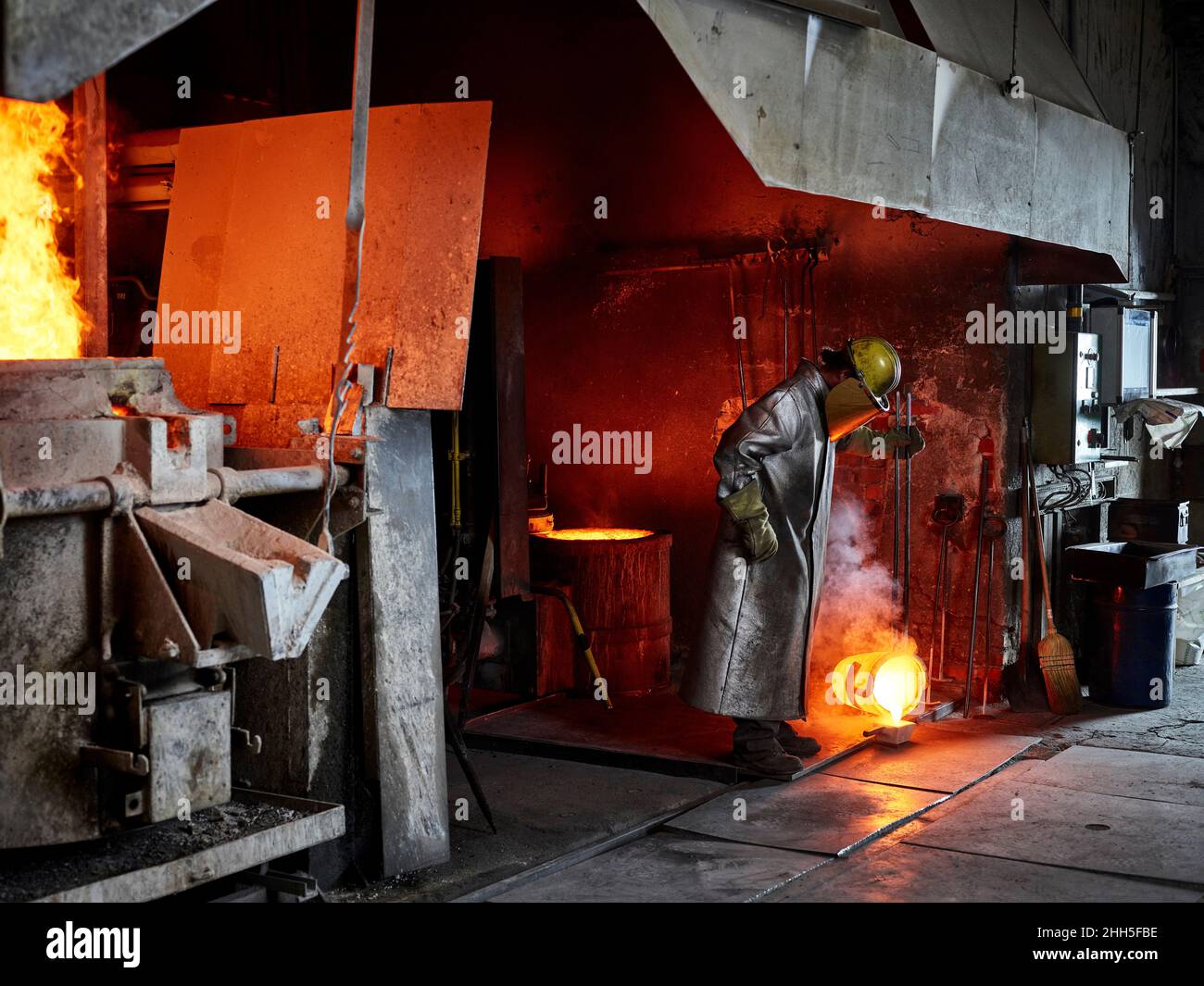 Craftsperson pouring burning metal while working in industry Stock