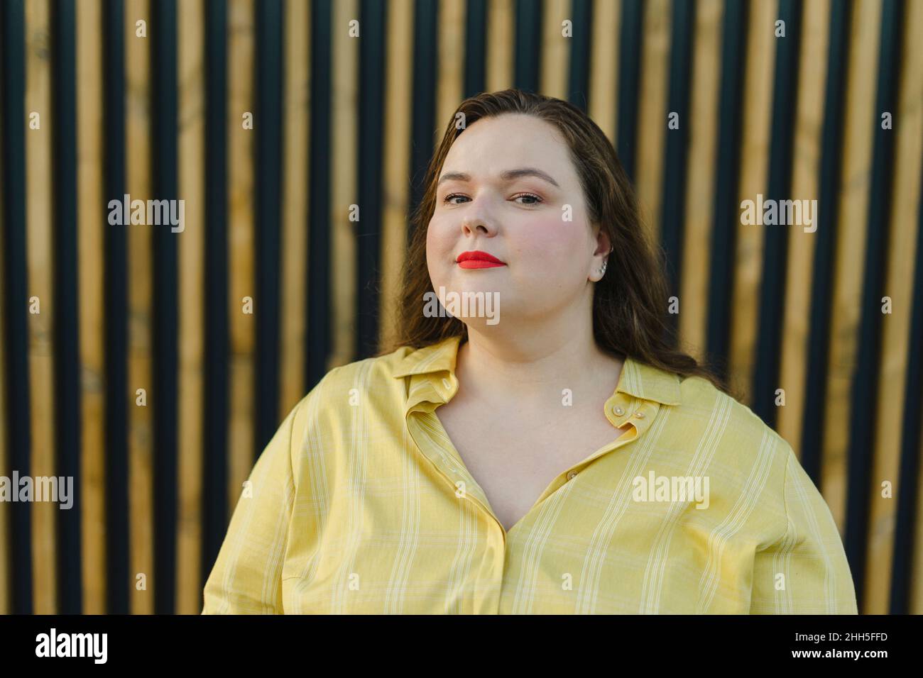 Plus size woman in front of wall Stock Photo