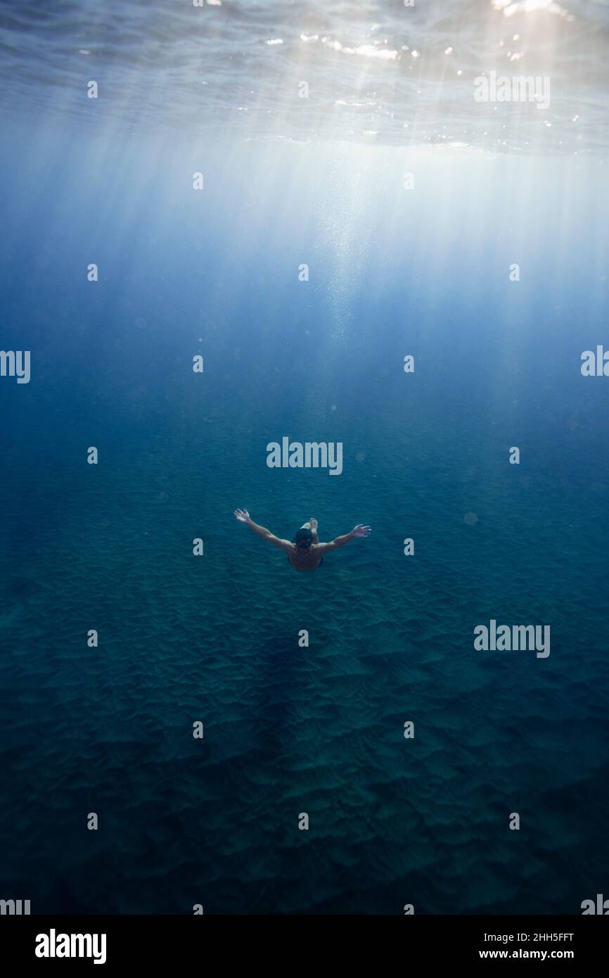 Young man swimming with arms outstretched undersea Stock Photo Alamy
