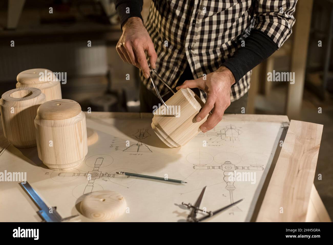 Woodworker measuring wood with equipment in workshop Stock Photo