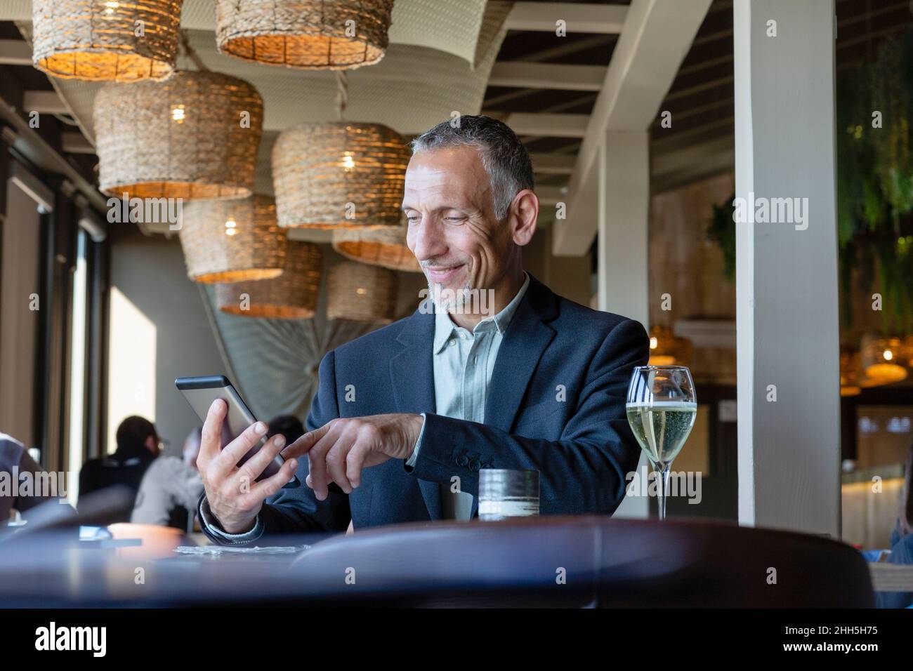 Smiling businessman using tablet PC in restaurant Stock Photo