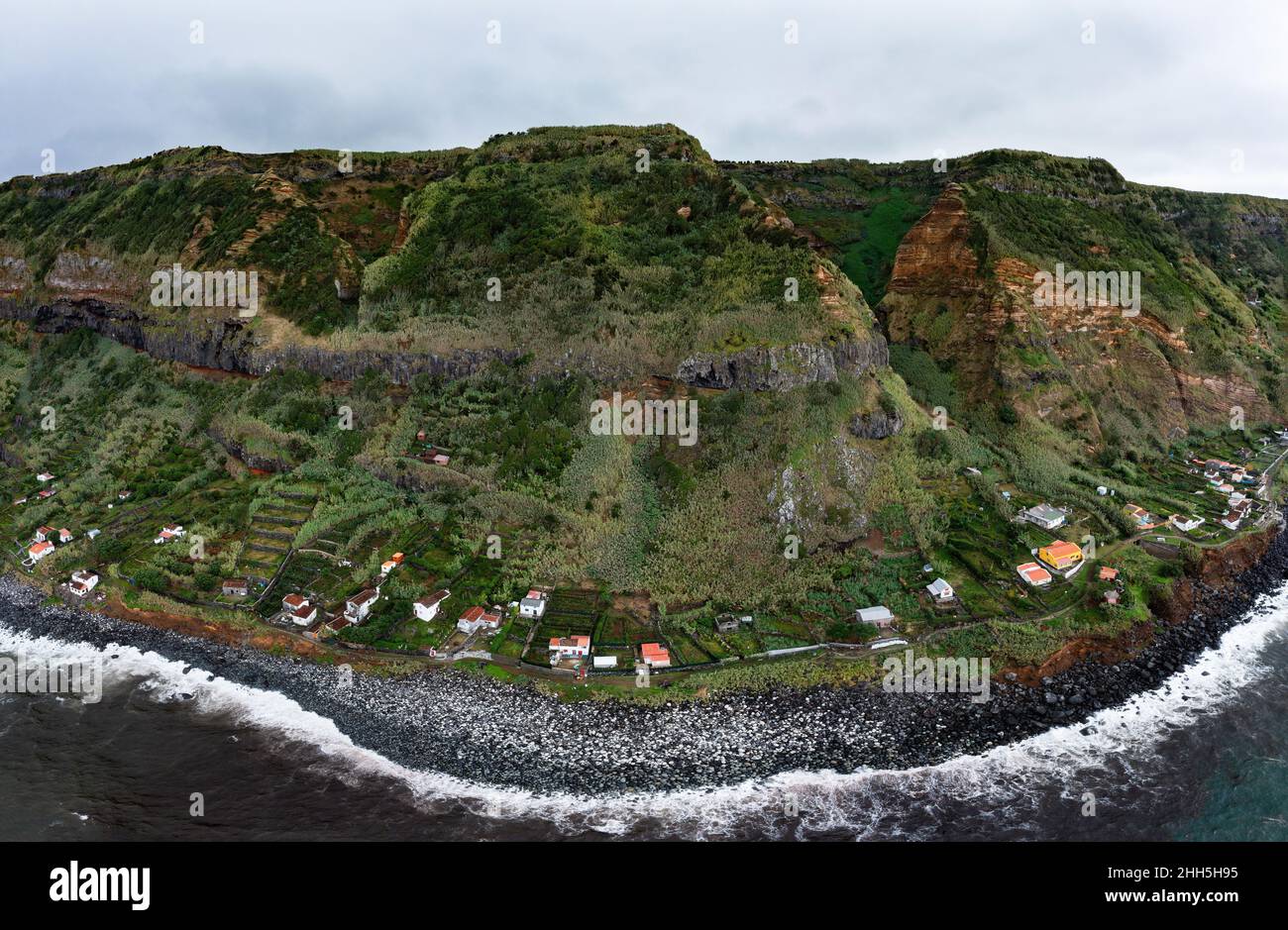 Houses on coast with mountain range at Rocha da Relva, Sao Miguel Island, Azores, Portugal Stock Photo