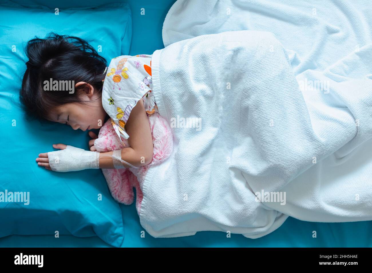 Top view Illness asian child admitted in hospital with saline