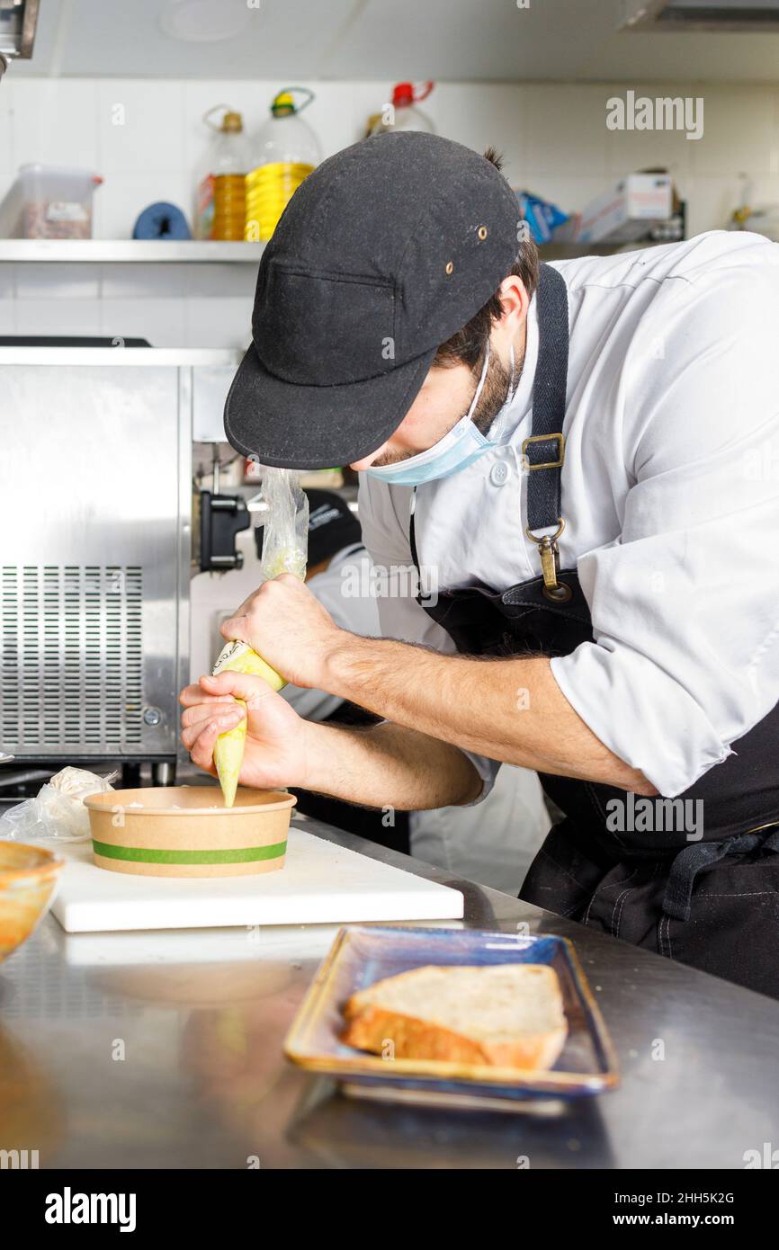 Male chef preparing food in plastic containers in kitchen at restaurant  during COVID-19 Stock Photo - Alamy