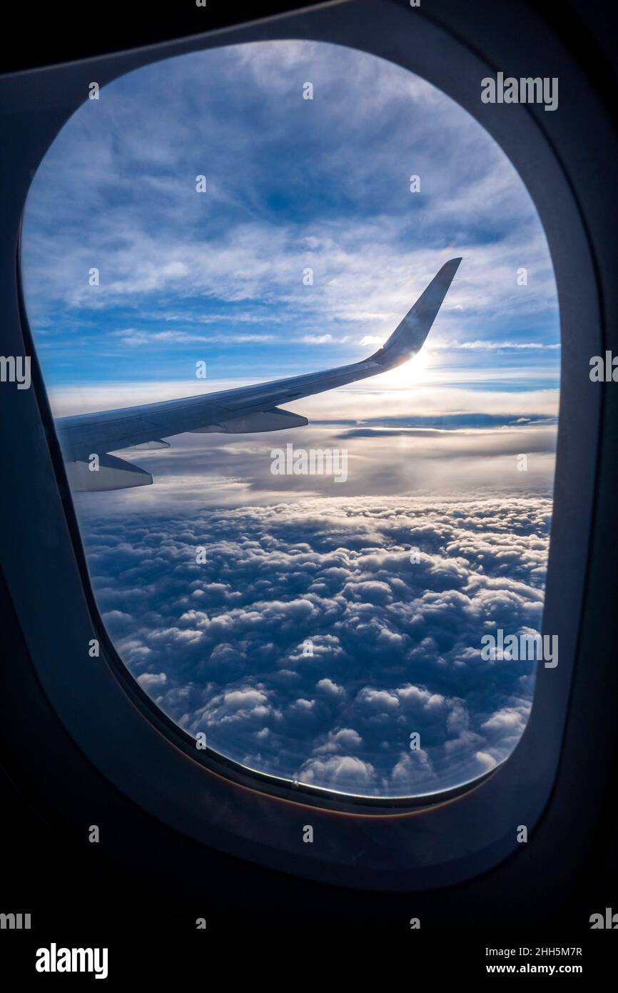 Thick clouds seen through window of airplane flying above Stock Photo