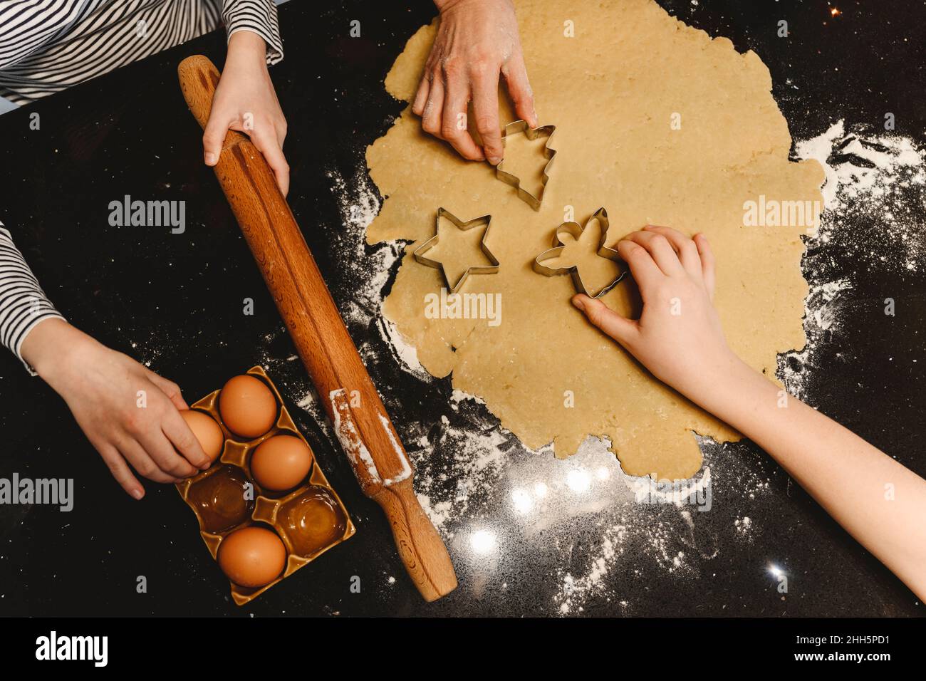 Family preparing cookies with cookie cutter on kitchen island Stock Photo