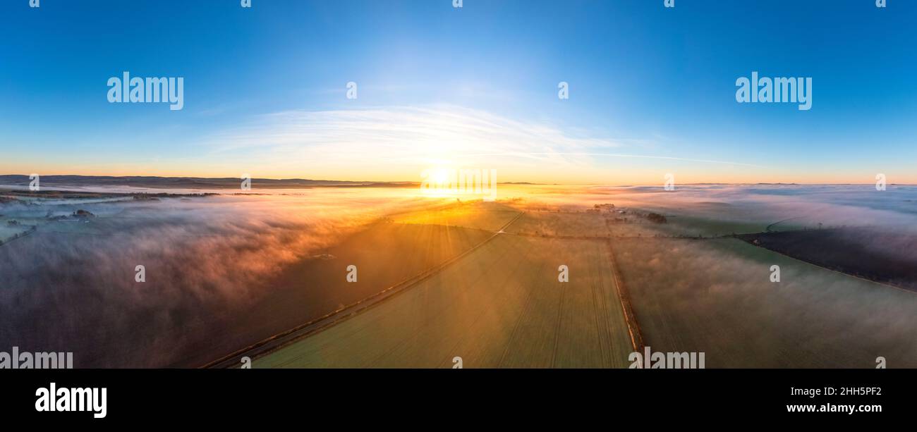 UK, Scotland, Kingston, Drone panorama of countryside fields at misty sunset Stock Photo