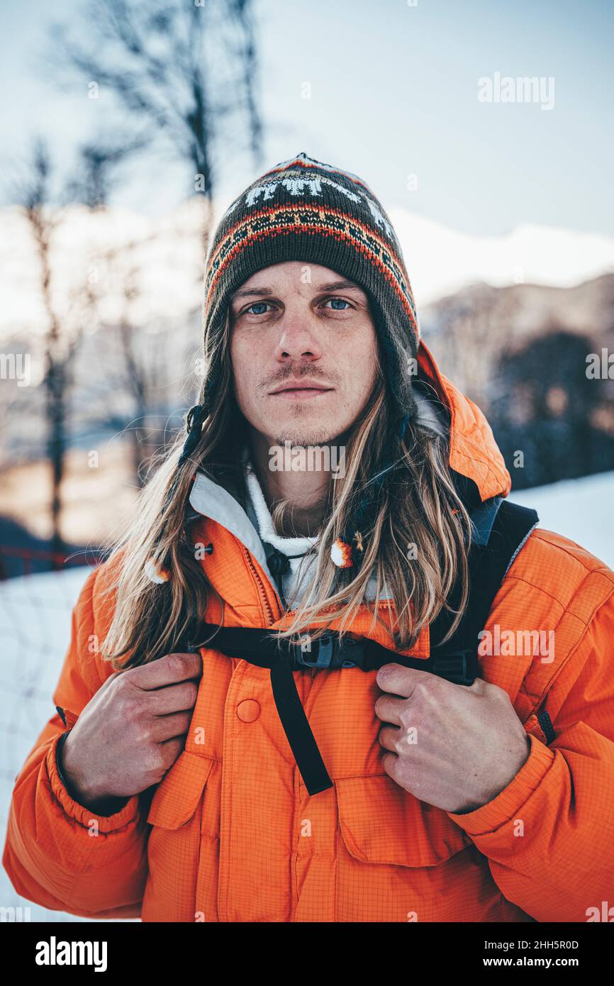 Hiker with knit hat carrying backpack at winter Stock Photo