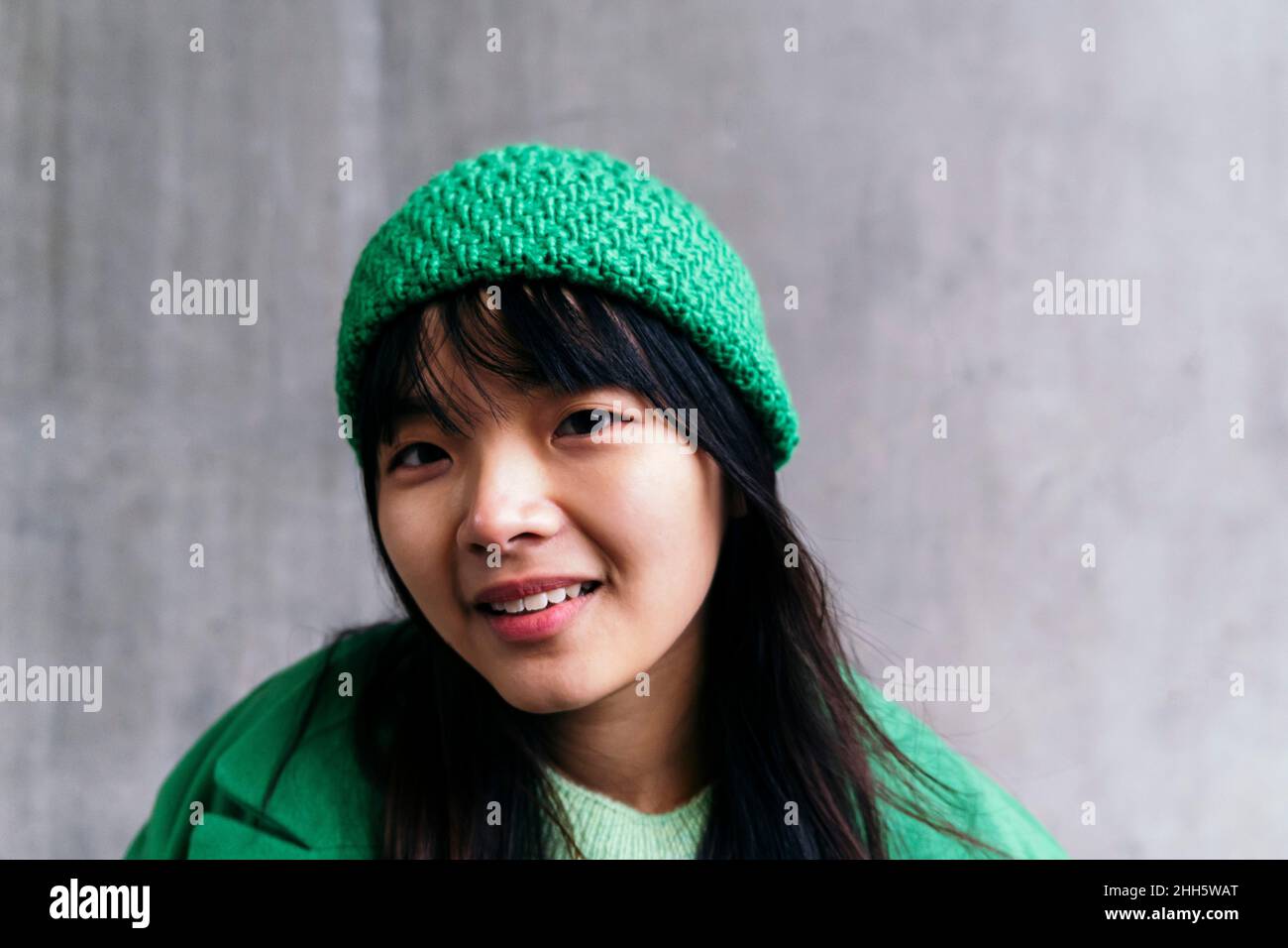 Smiling woman wearing green knit hat Stock Photo
