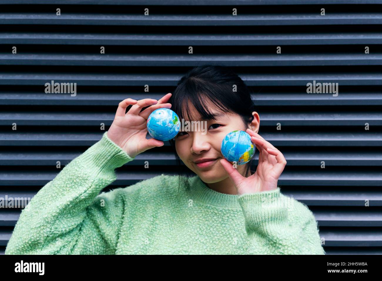 Woman with bangs holding small globes Stock Photo