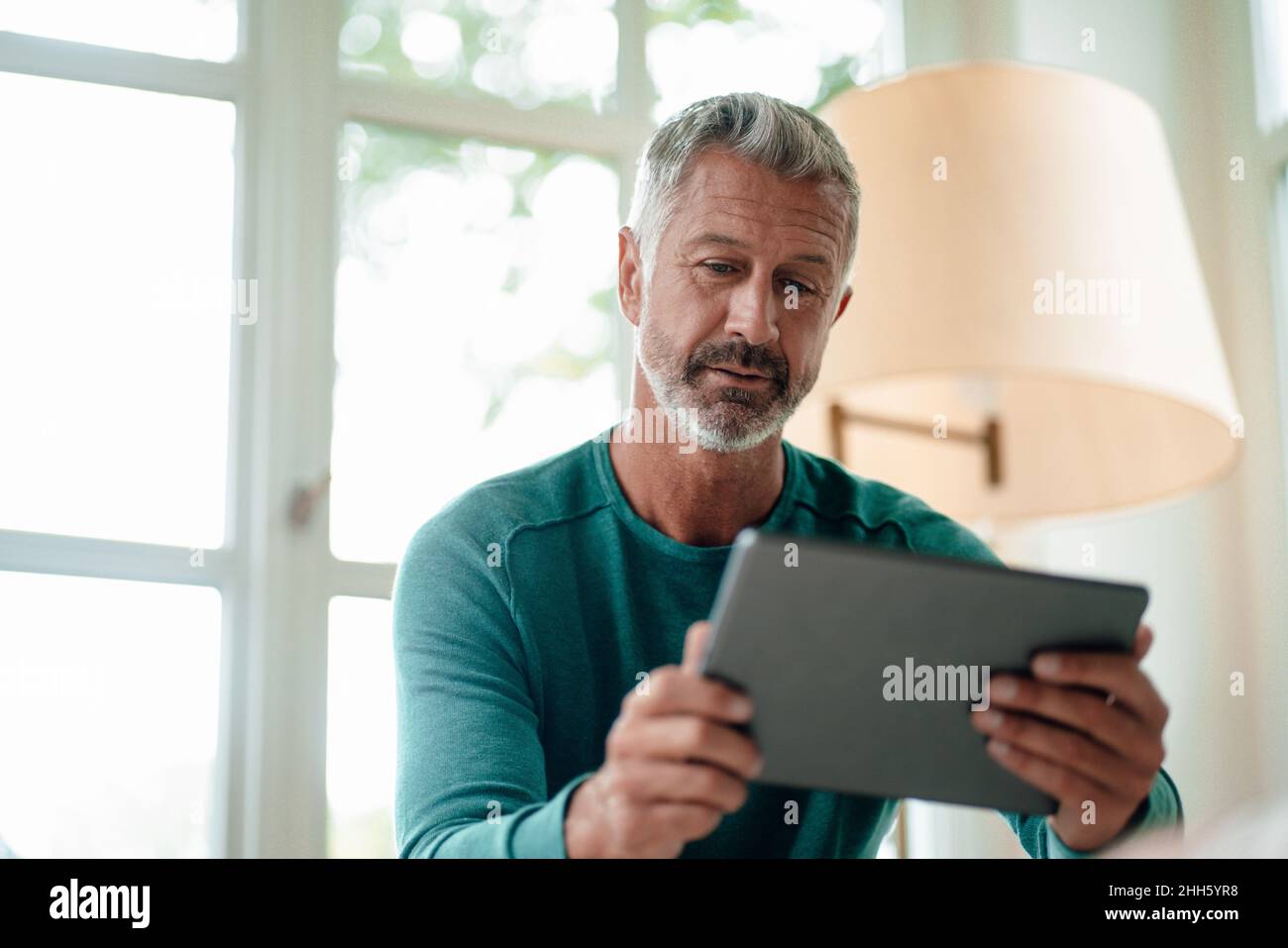 Mature man using tablet PC at home Stock Photo