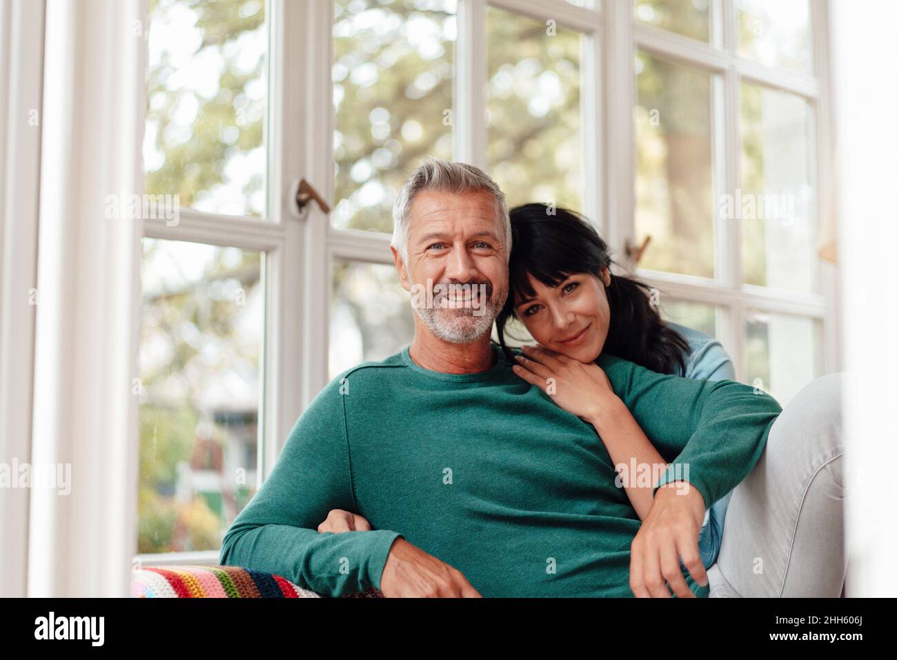 Woman leaning on man's shoulder at home Stock Photo