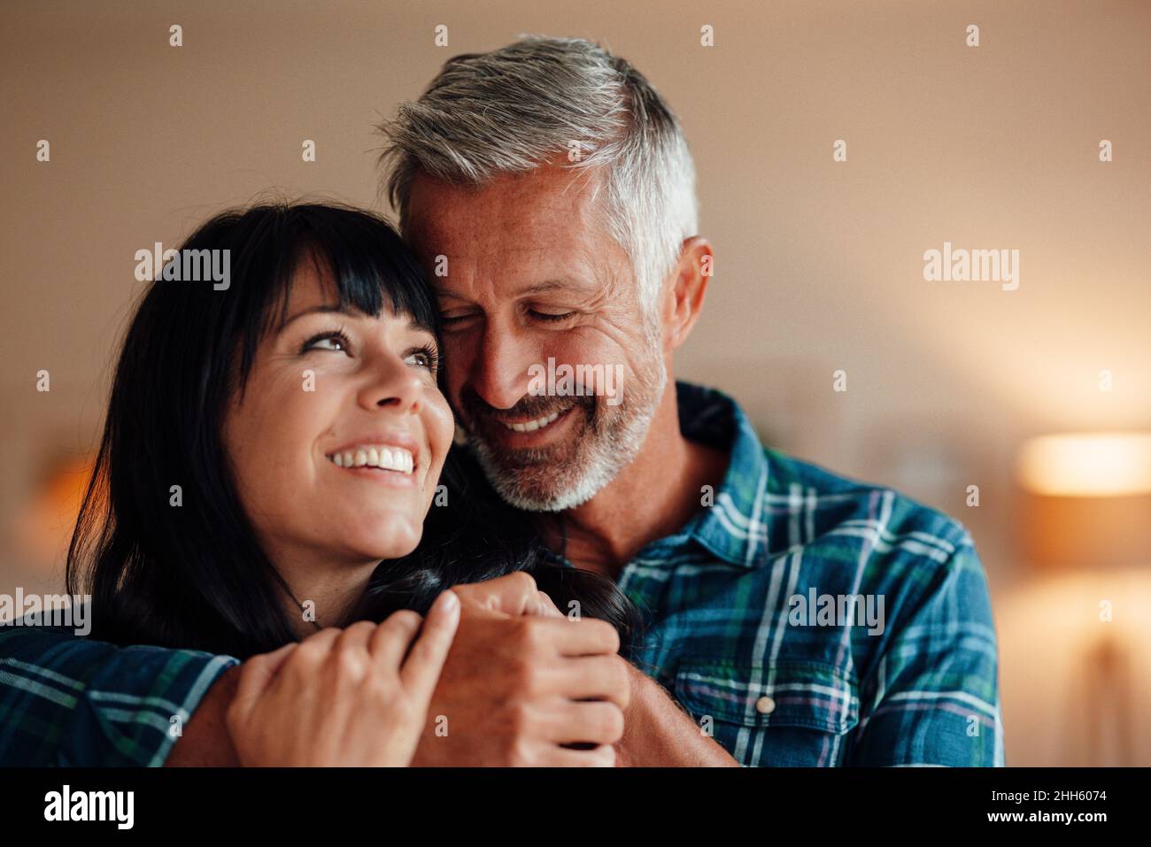 Smiling couple embracing at home Stock Photo