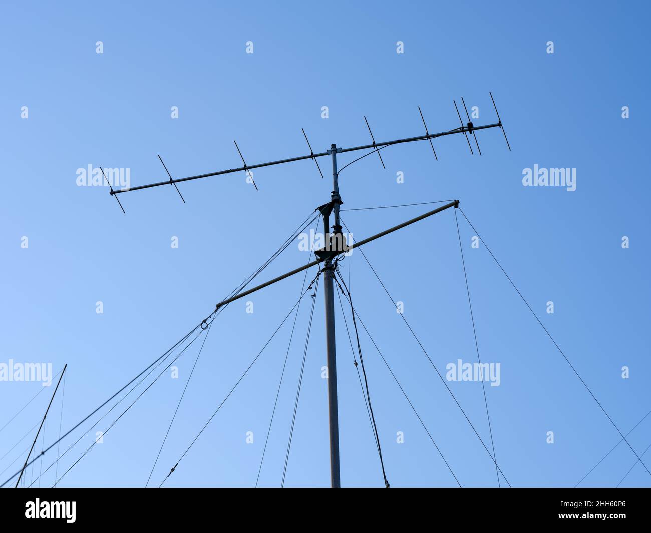 A VHF radio antenna with stay ropes against a blue sky Stock Photo - Alamy
