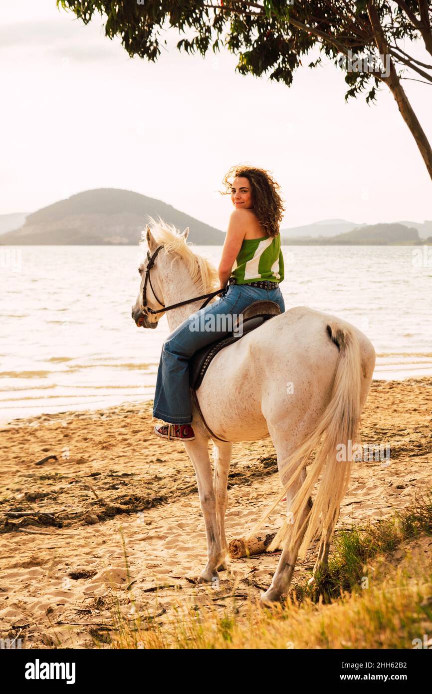 Young woman enjoying horse riding at waterfront Stock Photo
