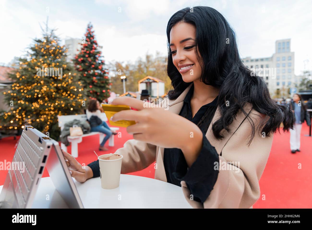 Woman with credit card online shopping on laptop on Christmas market Stock Photo