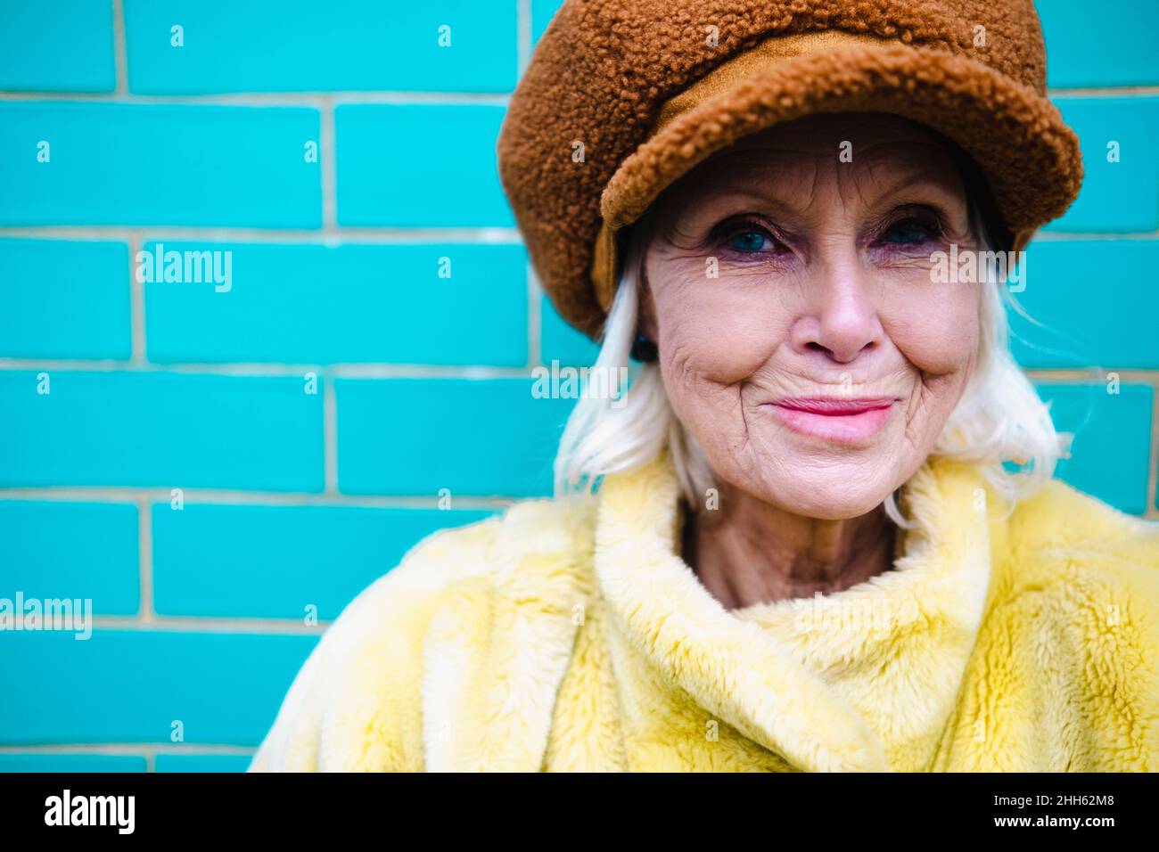 Smiling senior woman wearing cap and winter coat Stock Photo