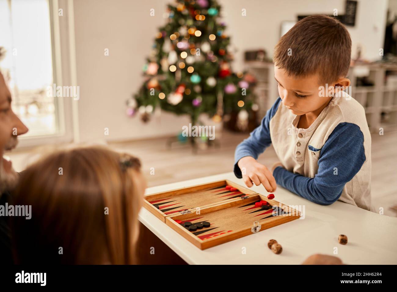 Boy throwing dice playing backgammon at home Stock Photo Alamy