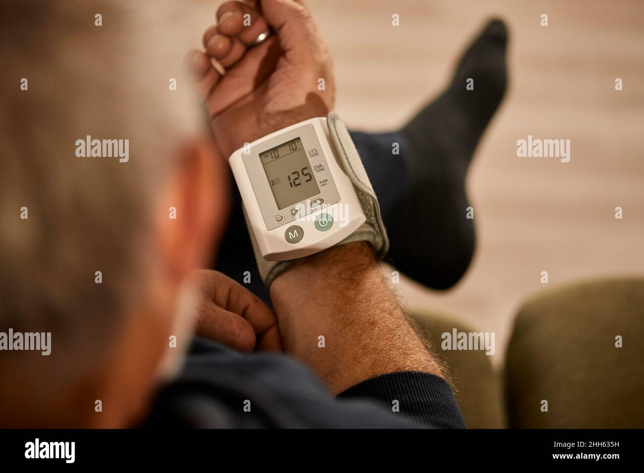 Man measuring blood pressure at home Stock Photo