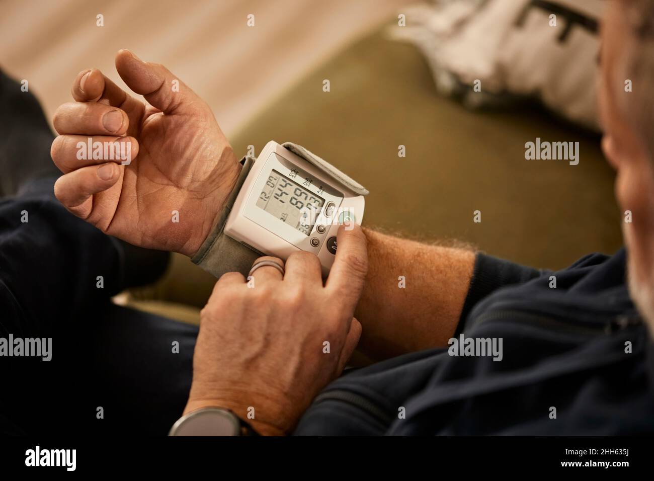Senior man checking blood pressure at home Stock Photo