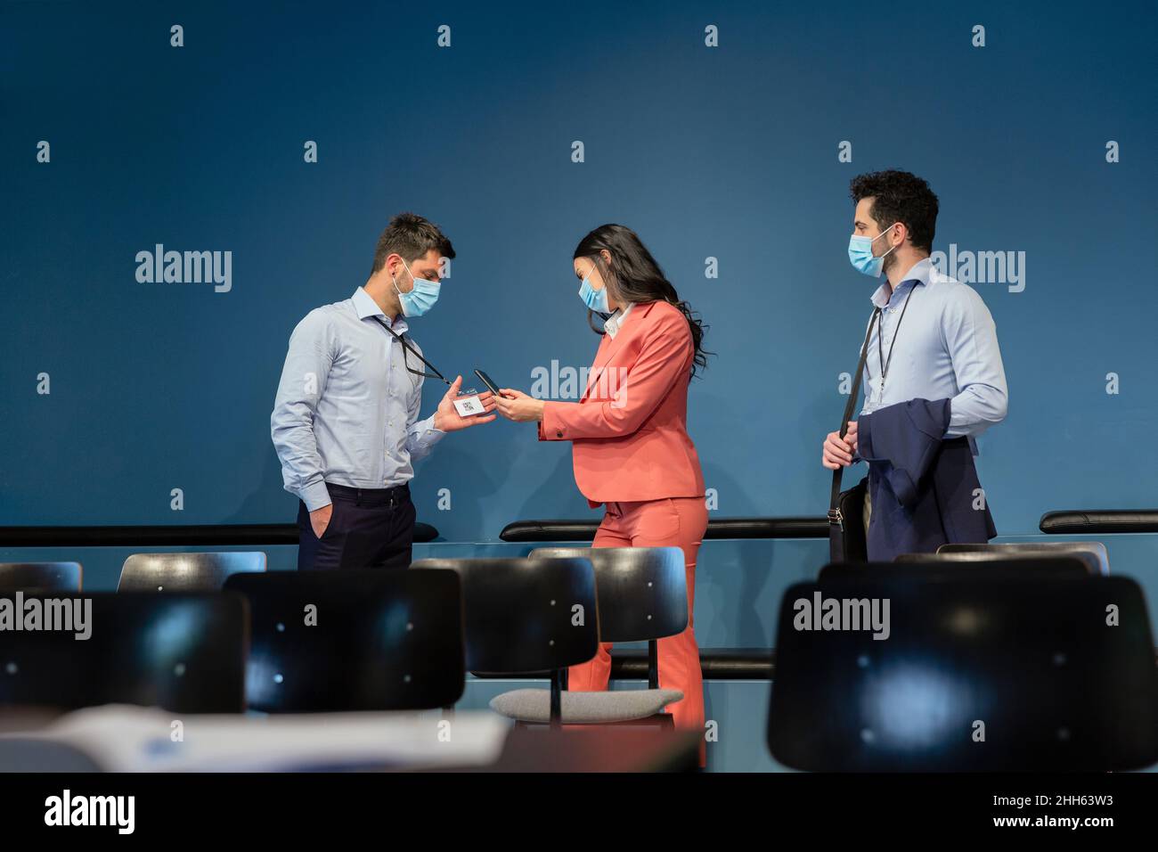 Businesswoman scanning identity of colleague through smart phone at conference Stock Photo