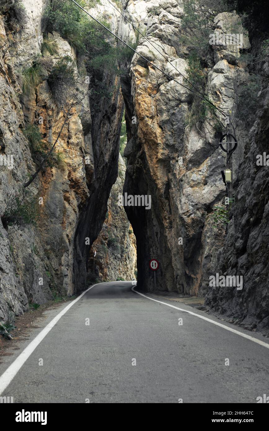 Empty single lane road through rocky cliffs Stock Photo