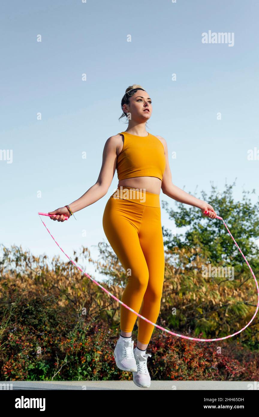 Determined young athlete exercising with jumping rope Stock Photo