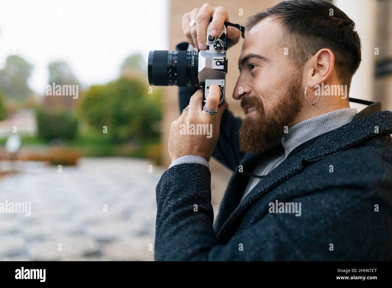 Young bearded man photographing through camera Stock Photo