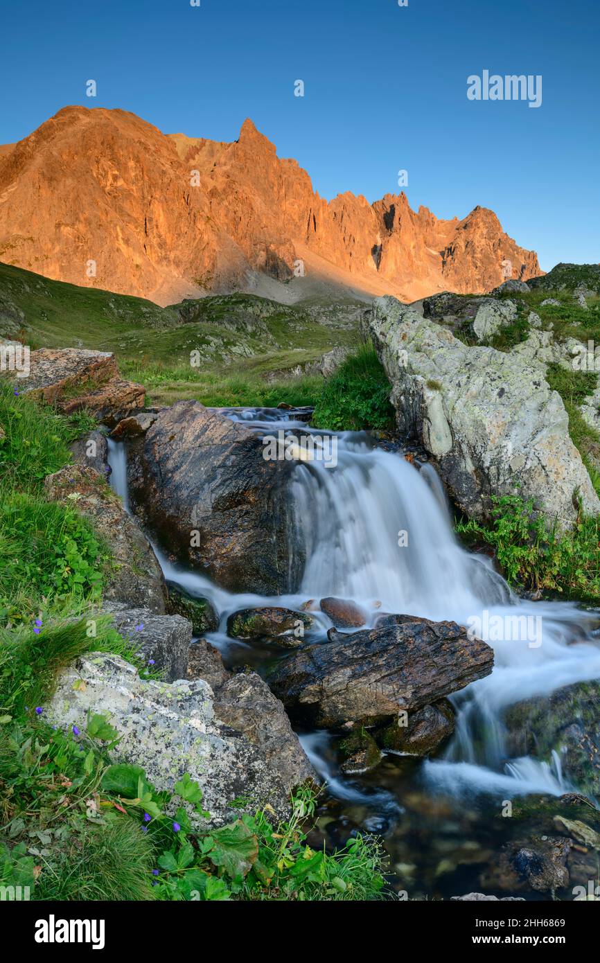 Water flowing on mountain with famous mountain in background, Pointe Des Cerces, France Stock Photo