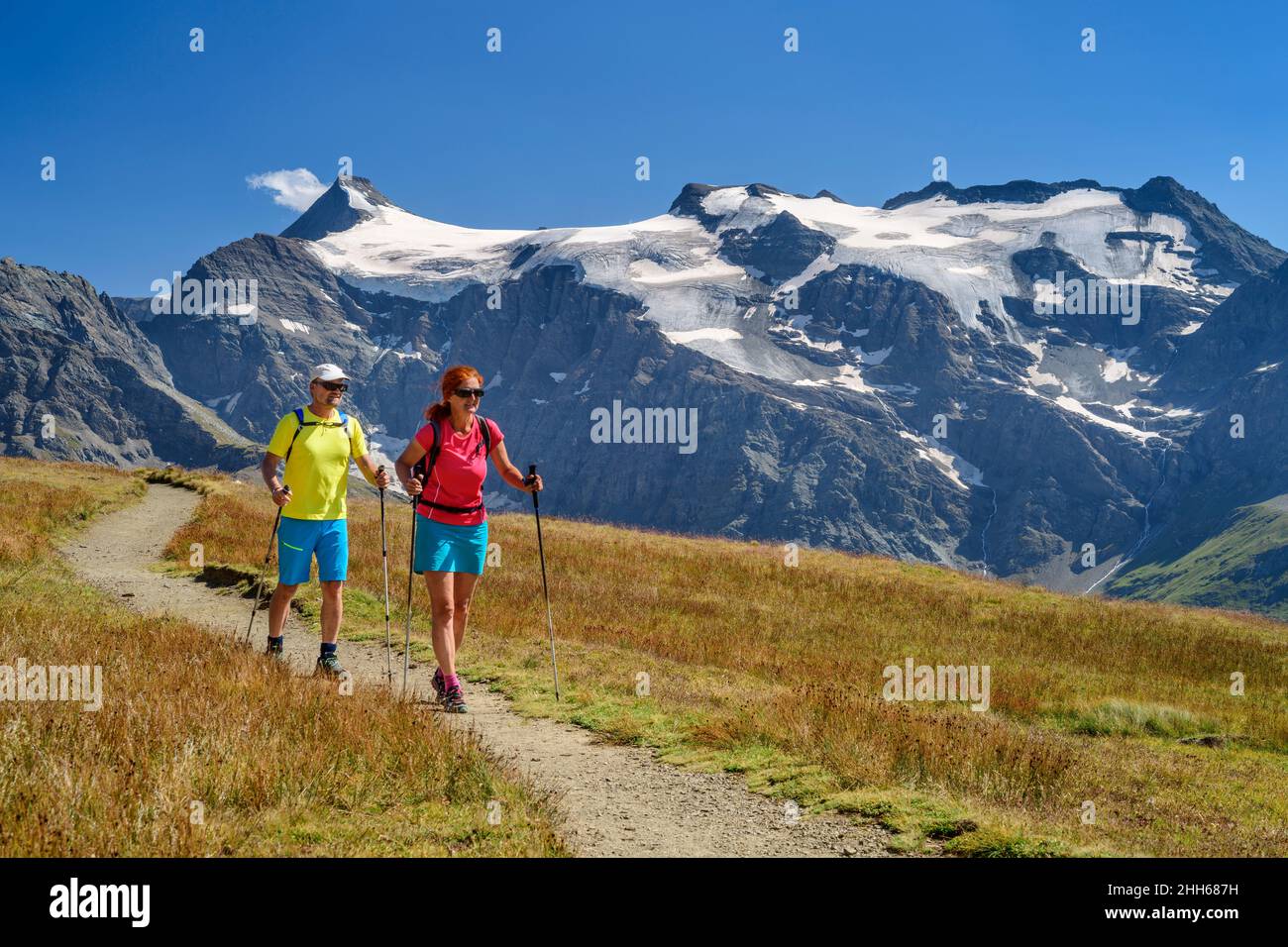 Hiker friends walking with hiking pole on mountain train at winter vacation, Vanoise National Park, France Stock Photo
