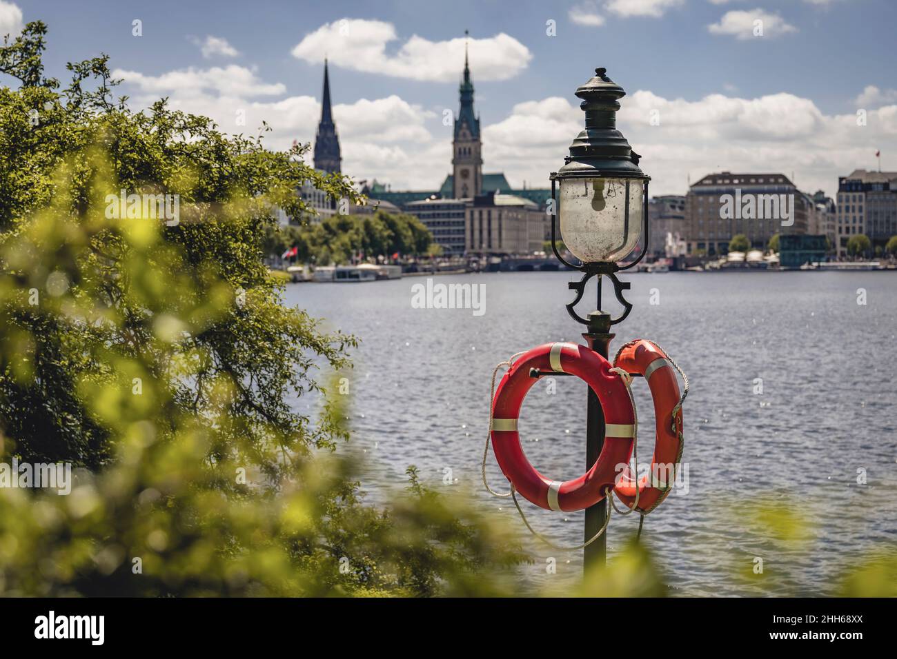 Germany, Hamburg, Life belts hanging on street light standing on shore of Inner Alster Lake Stock Photo