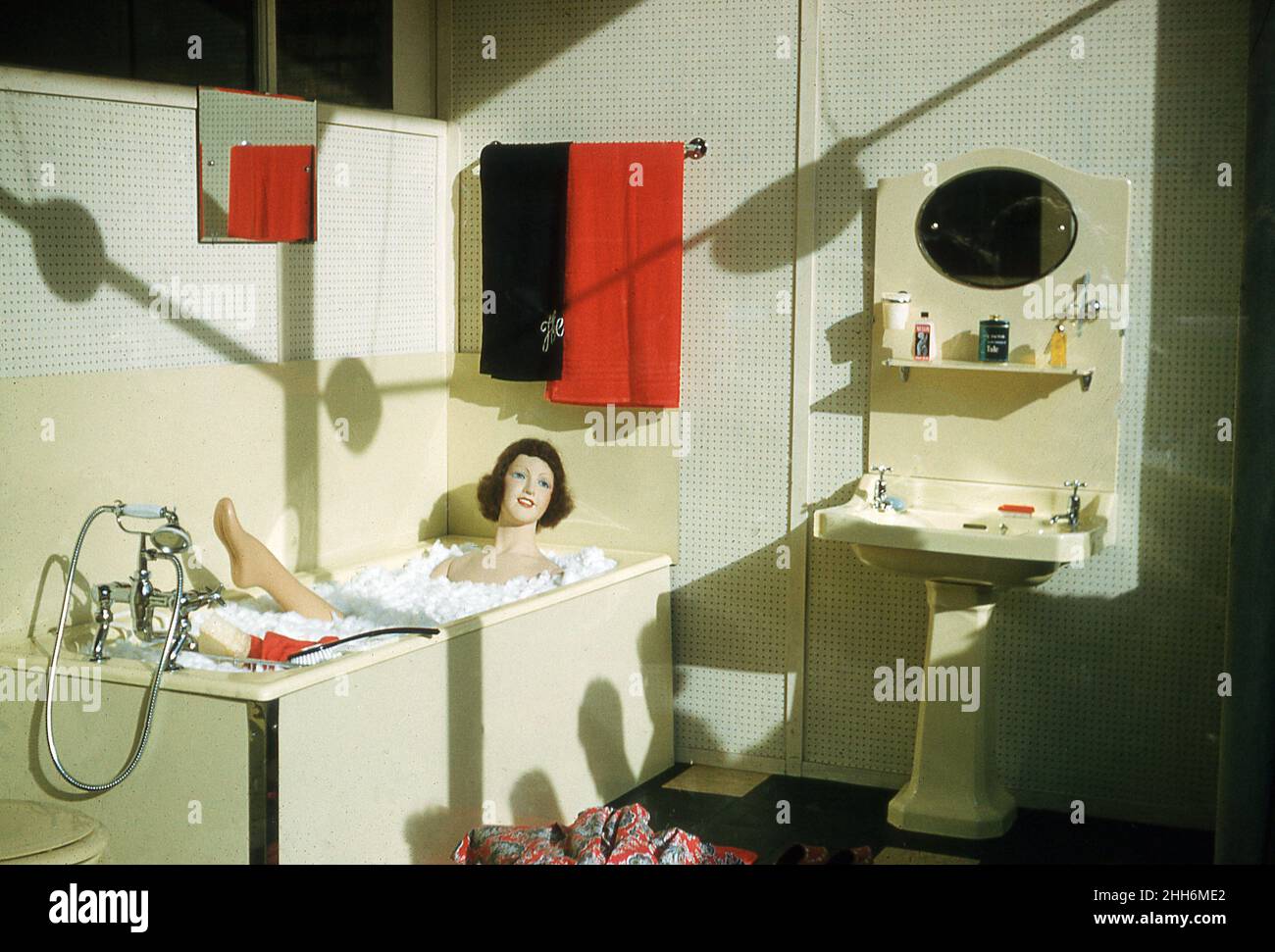 1959, historical, inside retailer Cookes of Waterloo Place, an in-store display for the latest in bathroom designs specially put together for the Londonderry Civic Week, Londonderry, Northern Ireland, UK. A female mannequin lies in pretend foam in the cream coloured bath. Stock Photo