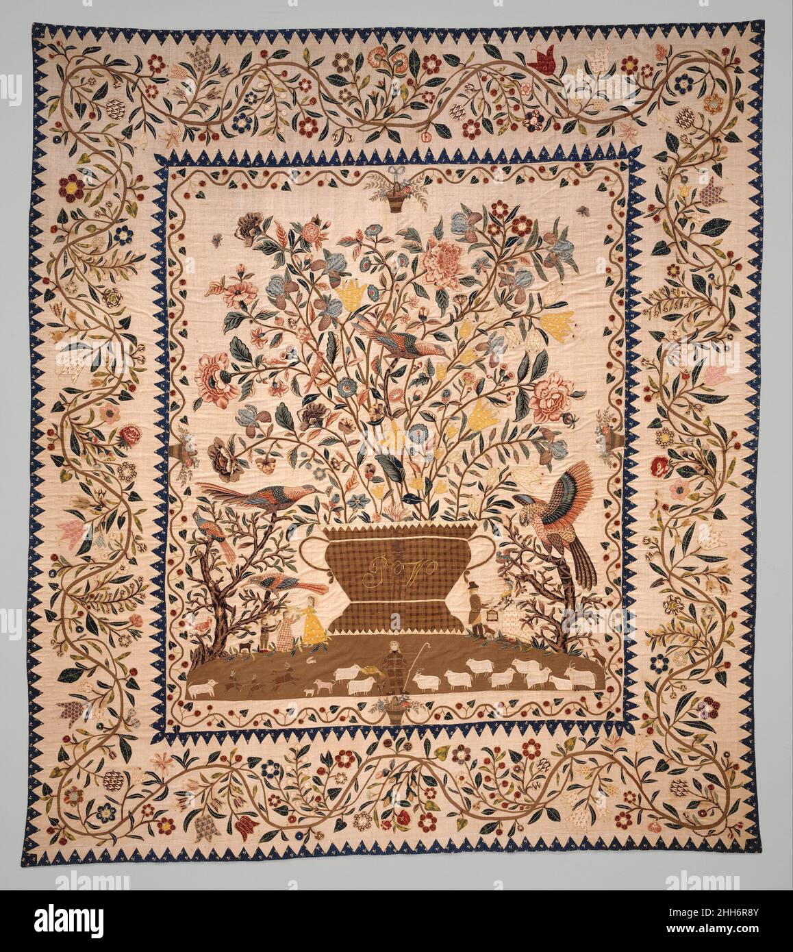 Phebe Warner Coverlet ca. 1803 Probably Sarah Furman Warner Williams American Made in about 1803 for Phebe Warner of New York, this bedcover's design relates more closely to eighteenth-century sources than to those of the nineteenth century. The maker was influenced by the central flowering-tree motif common to popular imported Indian bed hangings, called 'palampores,' as well as by the pastoral landscape needlework pictures often worked by young women. The coverlet's linen ground is appliquéd with large-patterned cotton chintzes and printed linens, as well as smaller-patterned cotton calicos Stock Photo