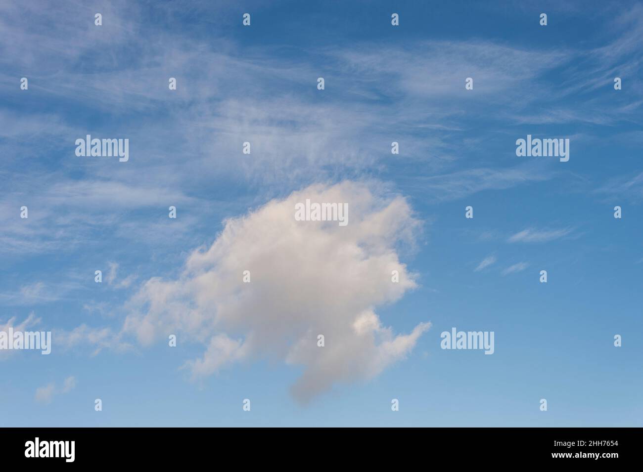 single cumulus cloud against a background of cirrus clouds. Stock Photo