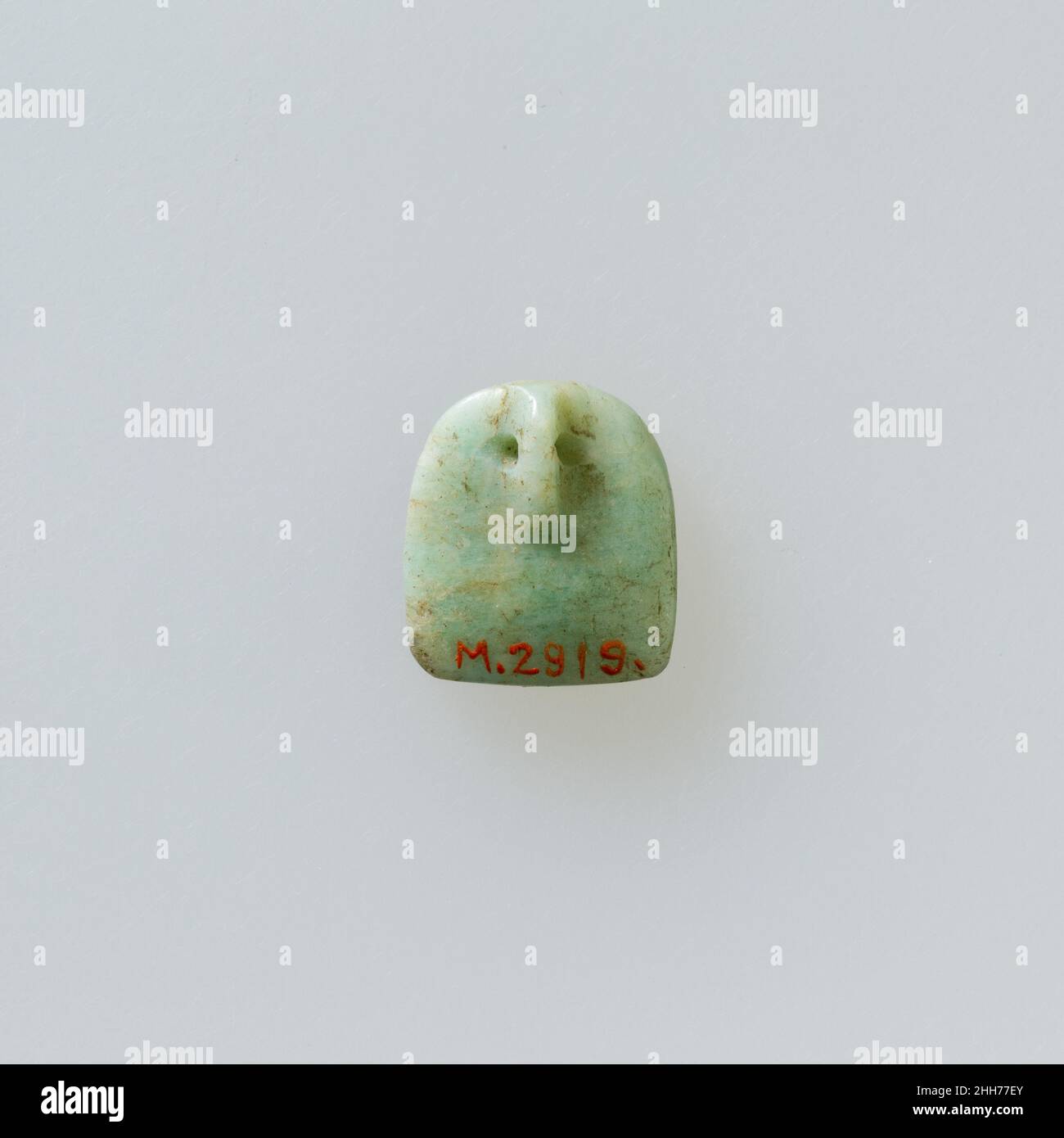 Shield shaped attachment or amulet with four holes connected by ...