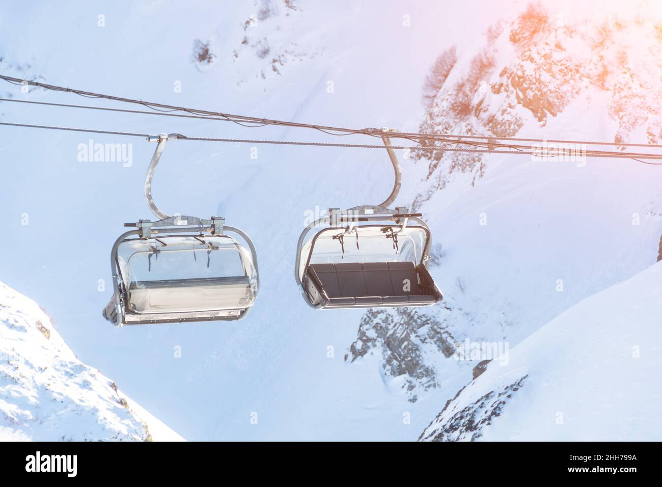 Cabin seats for skiers on a cable car against the backdrop of snow ...