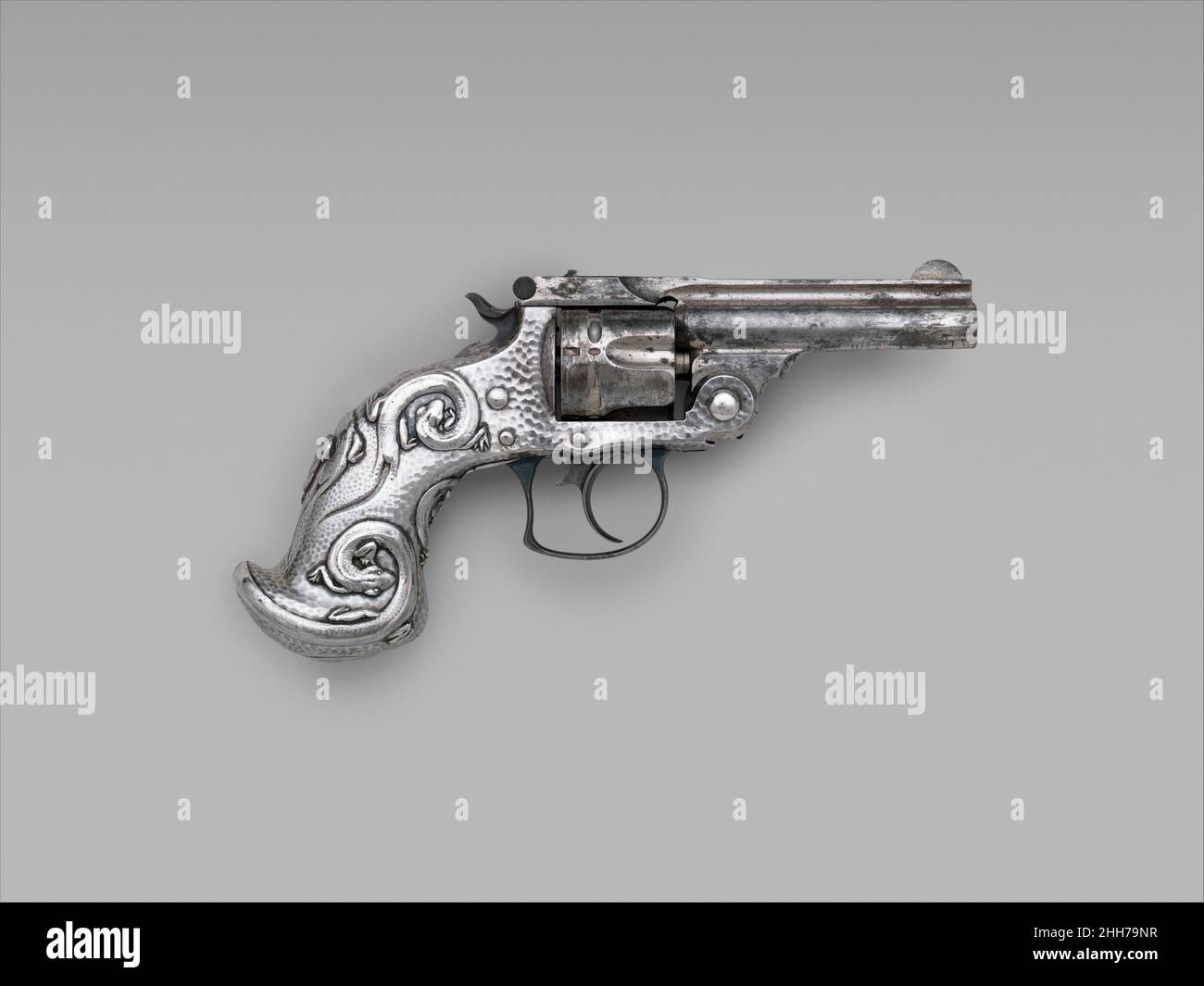 Smith and Wesson .38 Caliber Double-Action Revolver, serial no. 70002 1882–83 Smith & Wesson American The silver grip has a hammered surface popular in domestic silverware of the period. Its design reflects the elegant, whimsical style of Art Nouveau. The original design for the grip, dated 1883, is preserved in the Tiffany archives.. Smith and Wesson .38 Caliber Double-Action Revolver, serial no. 70002. American, Springfield, Massachusetts and New York. 1882–83. Steel, nickel, silver. Springfield, Massachusetts; New York, New York. Firearms-Pistols-Revolvers Stock Photo
