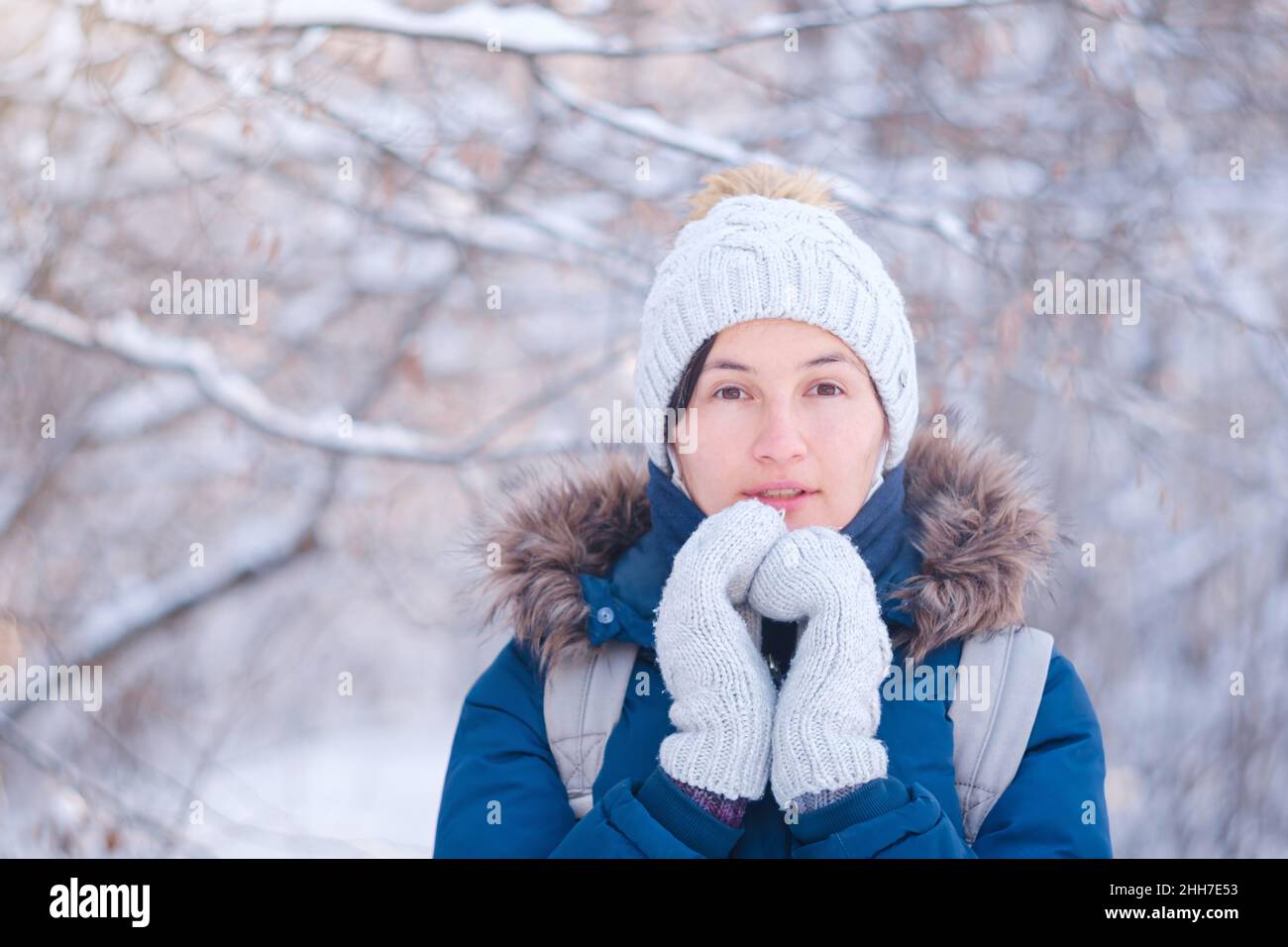 Happy Asian woman walking in winter snow forest. Cold weather hat and ...