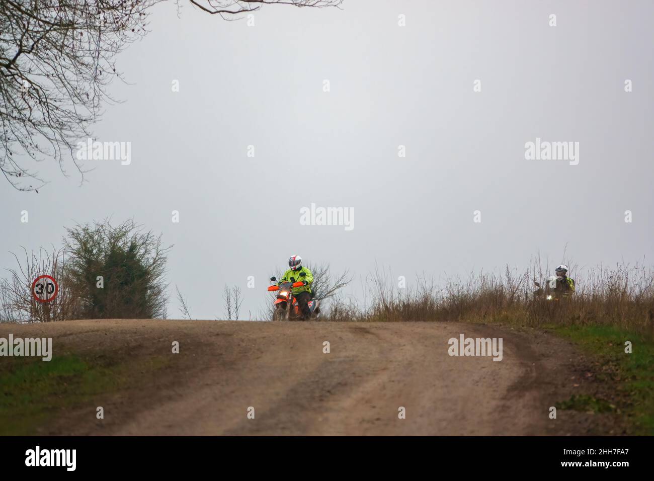a motor cyclist (biker) riding their offroad motorbike along a stone