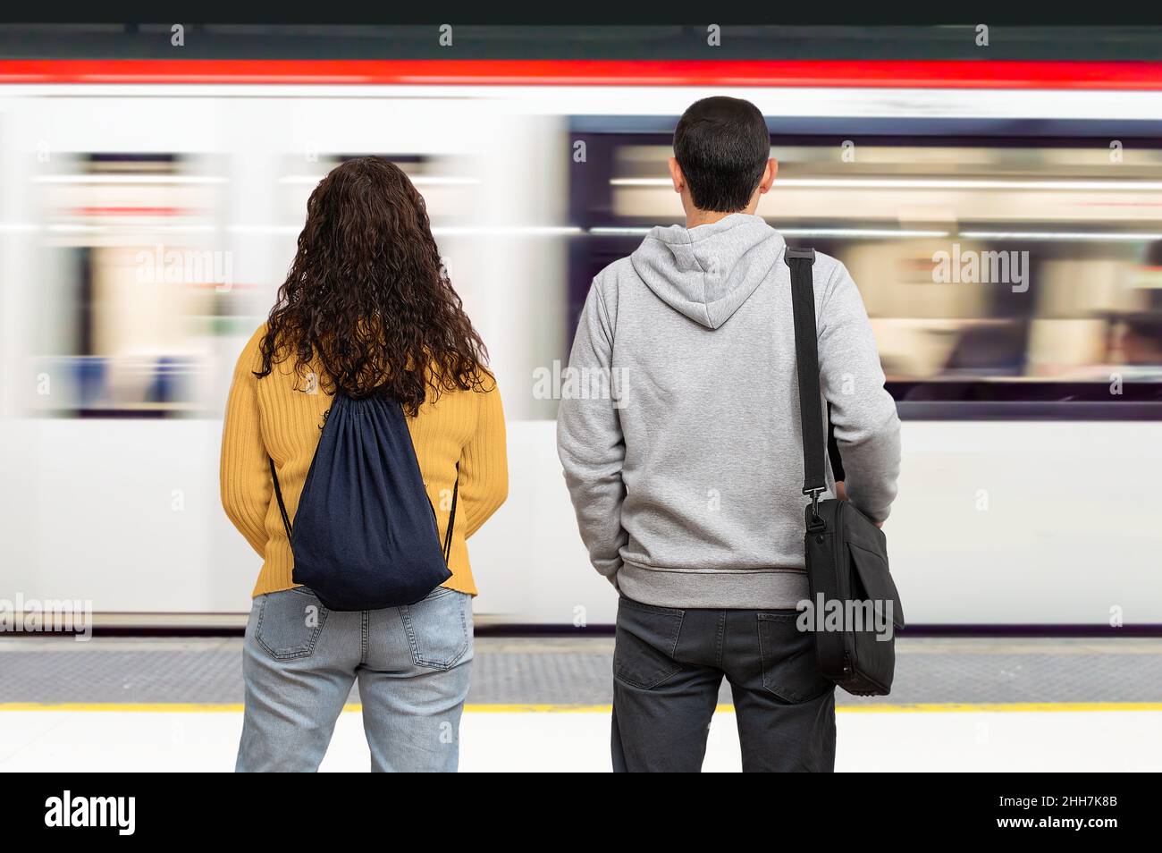 Couple waiting the train in the platform of subway station. Public transport concept. Stock Photo