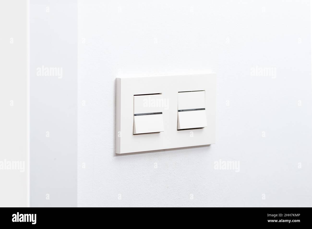 White light switch and faceplate on white wall Stock Photo