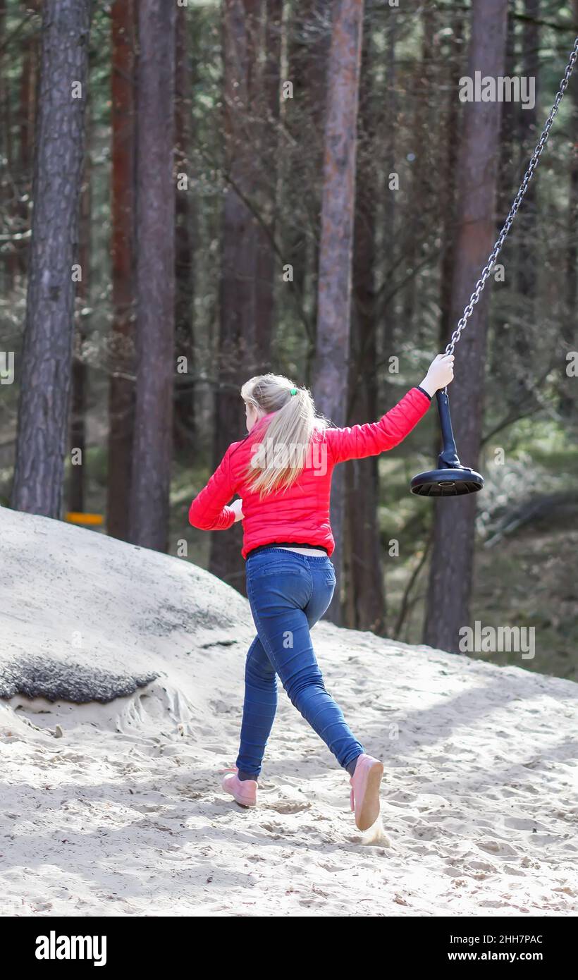 Happy blonde teenager girl jumping with bungee in park Stock Photo - Alamy